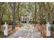 Long gravel driveway leading to a beautiful exterior with tall trees surrounding it at 2863 Jasper Blvd, Sullivans Island, SC 29482