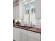 Charming kitchen featuring wood countertops, stainless steel sink, and white subway tile backsplash at 2863 Jasper Blvd, Sullivans Island, SC 29482