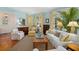 Inviting living room with white sofa, bright yellow curtains, tropical plant and beautiful decor at 2863 Jasper Blvd, Sullivans Island, SC 29482