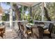 Charming screened porch with dining table and scenic backyard views at 2863 Jasper Blvd, Sullivans Island, SC 29482