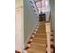 Carpeted stairs with a white banister leading to the upper level, with window and cabinet at 2863 Jasper Blvd, Sullivans Island, SC 29482