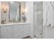 Bathroom with a vanity, decorative mirror, wall sconces and a glass enclosed shower with tiled walls at 2863 Jasper Blvd, Sullivans Island, SC 29482