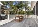 Outdoor dining area with a wooden table and bench on a spacious wooden deck surrounded by trees at 2928 Baywood Dr, Seabrook Island, SC 29455