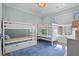 Bright bedroom featuring two sets of bunkbeds with blue accents and hardwood floors under a blue rug at 2928 Baywood Dr, Seabrook Island, SC 29455