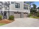 Stately home featuring a two-car garage, gray wood siding, and a well-maintained yard with lush greenery at 2928 Baywood Dr, Seabrook Island, SC 29455
