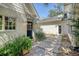 Backyard shows a landscaped walkway between two brick outbuildings with lush plantings and an overhead blue sky at 299 Hobcaw Dr, Mount Pleasant, SC 29464