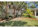 Beautiful backyard featuring lush grass, palm trees, and a charming home exterior with a cozy, welcoming entrance at 299 Hobcaw Dr, Mount Pleasant, SC 29464