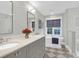 Elegant bathroom with double vanity, a soaking tub beneath a window, and modern fixtures at 299 Hobcaw Dr, Mount Pleasant, SC 29464
