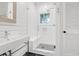 Well-lit bathroom with a glass enclosed shower, a white vanity and planked walls at 299 Hobcaw Dr, Mount Pleasant, SC 29464