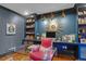 Home office with blue walls, built-in shelving, a glass desk, and hardwood floors at 299 Hobcaw Dr, Mount Pleasant, SC 29464