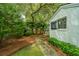 Landscaped backyard with a brick walkway and lush greenery surrounding the home at 313 Queen St, Mount Pleasant, SC 29464