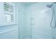 Modern bathroom featuring a tile surround shower, glass enclosure, and window with bright natural light at 313 Queen St, Mount Pleasant, SC 29464