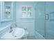 Light-filled bathroom featuring a tile surround shower, glass enclosure, and pedestal sink at 313 Queen St, Mount Pleasant, SC 29464