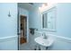 Stylish bathroom with beadboard paneling, pedestal sink, black and white tile floor, and modern finishes at 313 Queen St, Mount Pleasant, SC 29464