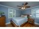 Cozy bedroom with a ceiling fan, hardwood floors, and bright natural light from two windows at 313 Queen St, Mount Pleasant, SC 29464