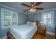 Cozy bedroom featuring a ceiling fan, hardwood floors, and bright windows with white shutters at 313 Queen St, Mount Pleasant, SC 29464