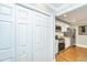 View of the kitchen from the pantry which has stainless steel appliances and white cabinetry at 313 Queen St, Mount Pleasant, SC 29464