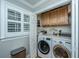 A practical laundry room with a side-by-side washer and dryer and storage cabinets at 313 Queen St, Mount Pleasant, SC 29464