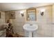 Classic-style bathroom with pedestal sink, tiled walls, and elegant sconces at 38 State St # 2, Charleston, SC 29401