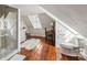 Bright attic bathroom featuring hardwood floors, a shower, and built in desk at 38 State St # 2, Charleston, SC 29401