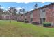 Well-maintained apartment exterior featuring brick accents and a spacious lawn, shaded by mature trees at 402 Andrea Ln, Hanahan, SC 29410