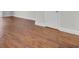 Close-up of new hardwood style flooring with white trim and baseboards at 402 Andrea Ln, Hanahan, SC 29410