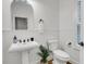 Bright bathroom features pedestal sink, toilet, wainscoting, and a view into an adjacent room at 4057 E Amy Ln, Johns Island, SC 29455