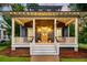 Cozy front porch with classic rocking chairs, ambient lighting, and a welcoming entrance with beautiful landscaping at 4057 E Amy Ln, Johns Island, SC 29455