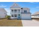 Charming two-story home with a double porch, bright blue door and well-manicured lawn in a Gathering-friendly neighborhood at 415 Ribiero Dr, Summerville, SC 29486