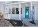 Close-up of a charming covered front porch with a bright blue door, white railings, and decorative plants at 415 Ribiero Dr, Summerville, SC 29486