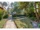 Secluded backyard garden featuring brick pathways, manicured ivy, and mature trees for serene outdoor living at 42 Barre St, Charleston, SC 29401