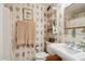 Charming bathroom features fern wallpaper, pedestal sink, and decorative shelving at 42 Barre St, Charleston, SC 29401