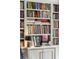 Close up of a bookshelf with assorted books, decorative items, and a small table lamp for focused lighting at 42 Barre St, Charleston, SC 29401