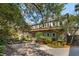 Charming two-story brick home featuring lush greenery, traditional shutters, and a spacious gravel driveway at 42 Barre St, Charleston, SC 29401