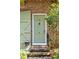 Charming green front door with a brass door knocker on a brick home at 42 Barre St, Charleston, SC 29401