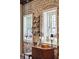 Bright interior shot featuring exposed brick, a decorative shelf and period furnishings for timeless appeal at 42 Barre St, Charleston, SC 29401