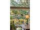 Sunlit view through a window, showcasing the lush garden, hanging plants, and a portion of outdoor furniture at 42 Barre St, Charleston, SC 29401