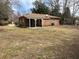 Back exterior view of cozy brick home showing large yard with mature trees at 4451 Donwood Dr, Ladson, SC 29456