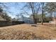 Large backyard with leafless trees and a blue house exterior at 4788 Porter Dr, North Charleston, SC 29420