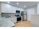 Modern kitchen with white cabinetry, granite countertops, and stainless steel appliances at 546 Tayrn Dr, Charleston, SC 29492