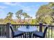 Balcony featuring a bistro set and a stunning view of the marsh and mature trees at 57 Goldenrod Ct, Kiawah Island, SC 29455