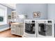 Well-lit laundry room with stainless steel sink, modern appliances, and built-in shelving at 57 Goldenrod Ct, Kiawah Island, SC 29455
