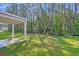 Backyard with green grass and covered patio with wooded view at 5206 Cottage Lndg Dr, Summerville, SC 29485
