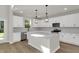 Bright kitchen with island featuring stainless steel appliances, white cabinets, quartz countertops and pendant lighting at 5206 Cottage Lndg Dr, Summerville, SC 29485