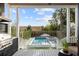 Covered porch with a view of the sparkling pool, spa, and privacy landscaping at 71 Moultrie St, Charleston, SC 29403