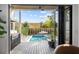 Covered outdoor living space with a built-in grill, view of a private pool and landscaped backyard at 71 Moultrie St, Charleston, SC 29403