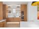 Kitchen area featuring wooden cabinets, marble countertops, shelving, wine fridge and sleek faucet at 71 Moultrie St, Charleston, SC 29403