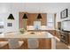 Bright kitchen featuring a marble island, wooden cabinets, stainless steel appliances and modern pendant lighting at 71 Moultrie St, Charleston, SC 29403