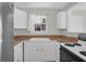 Bright kitchen area with white cabinets, neutral counter tops, and natural light from window at 867 Colony Dr # F-82, Charleston, SC 29407
