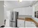 A kitchen features white cabinets, stainless steel appliances, and a washer/dryer combo at 867 Colony Dr # F-82, Charleston, SC 29407